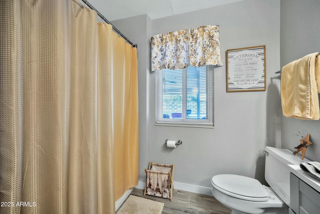 bathroom featuring walk in shower, hardwood / wood-style floors, and toilet