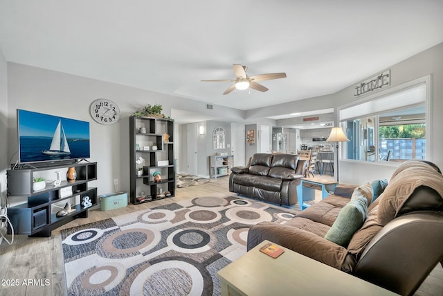 living room with ceiling fan and light hardwood / wood-style floors