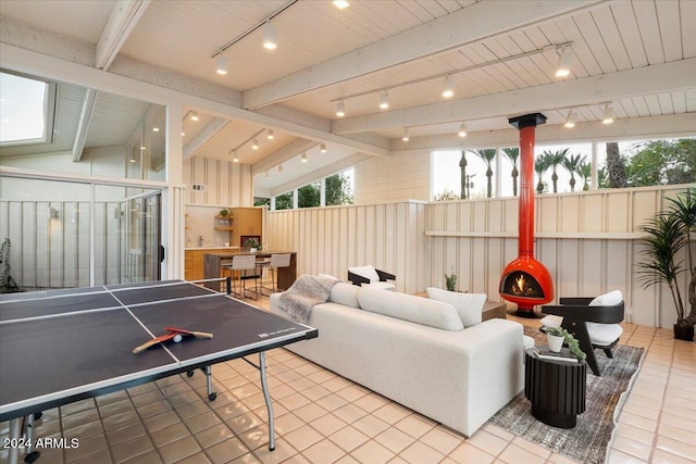 recreation room featuring lofted ceiling with beams, tile patterned floors, and track lighting