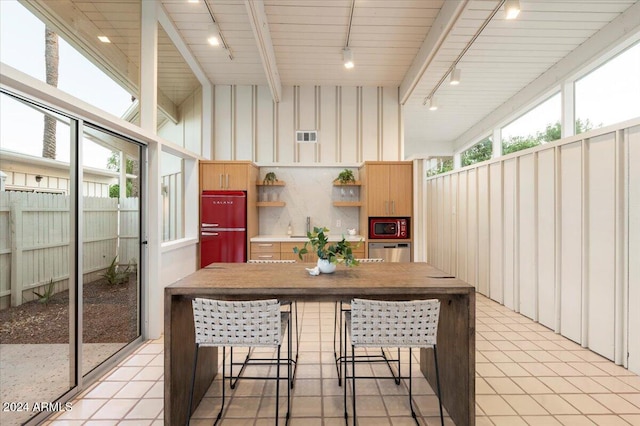 sunroom / solarium with wood ceiling, lofted ceiling with beams, sink, and rail lighting