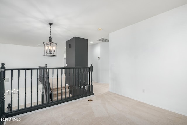 corridor with light colored carpet and a notable chandelier