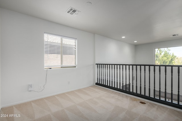 empty room with light carpet and a wealth of natural light