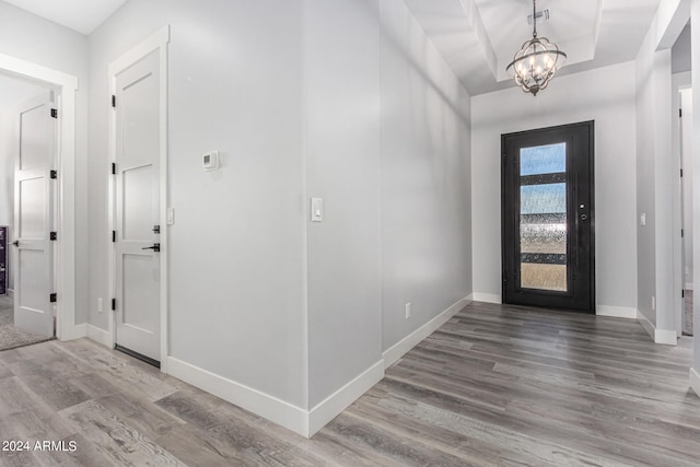 entryway featuring wood-type flooring and a chandelier