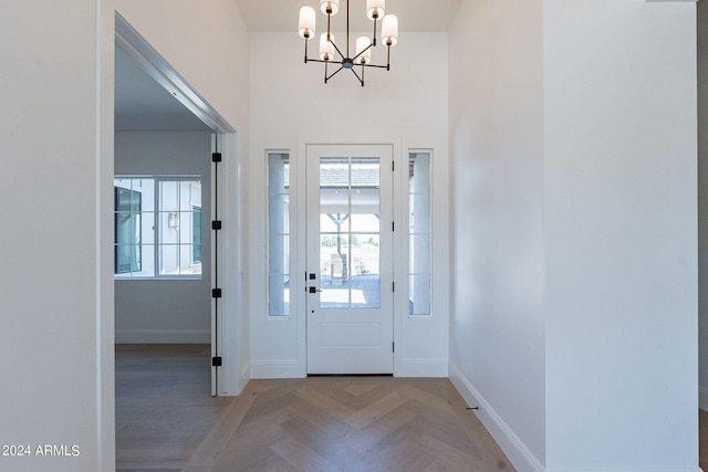 entrance foyer with a notable chandelier and parquet flooring