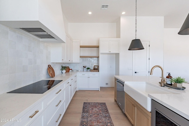 kitchen with backsplash, light wood-type flooring, light stone counters, and custom exhaust hood