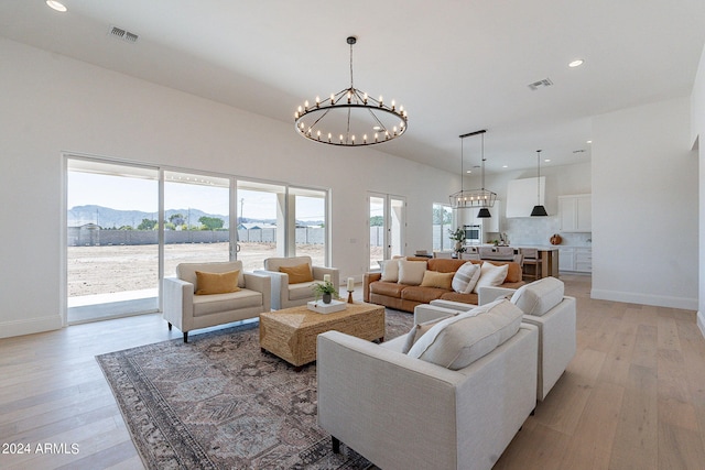 living room with an inviting chandelier, a mountain view, and light hardwood / wood-style floors