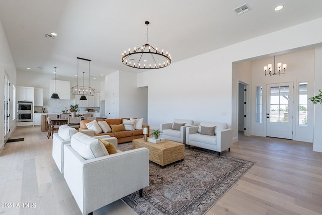 living room with a towering ceiling, hardwood / wood-style flooring, and a chandelier