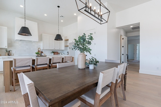 dining space with a chandelier and light hardwood / wood-style floors