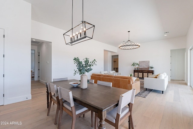 dining space featuring a notable chandelier and light wood-type flooring