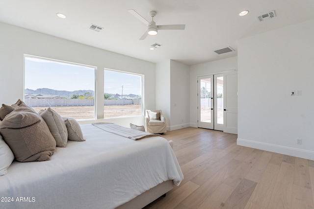 bedroom featuring ceiling fan, access to exterior, light hardwood / wood-style flooring, and french doors