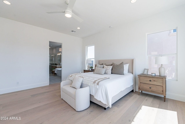 bedroom featuring ceiling fan, ensuite bath, and light hardwood / wood-style flooring