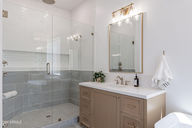 bathroom with a shower with shower door and vanity