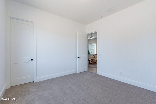 carpeted spare room featuring ceiling fan