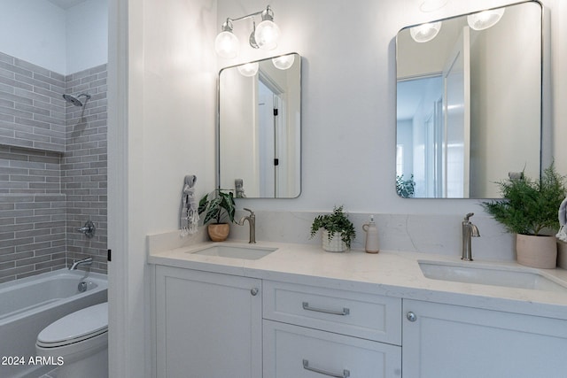 full bathroom with double vanity, toilet, and tiled shower / bath combo