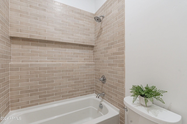 bathroom with toilet and tiled shower / bath combo