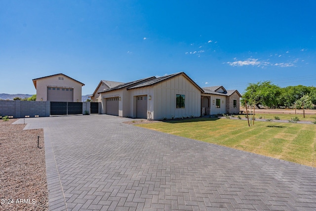 ranch-style house featuring a garage and a front lawn