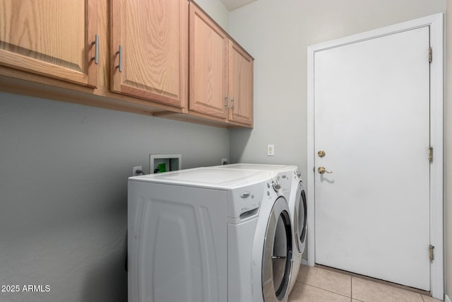 clothes washing area featuring light tile patterned flooring, cabinets, and independent washer and dryer