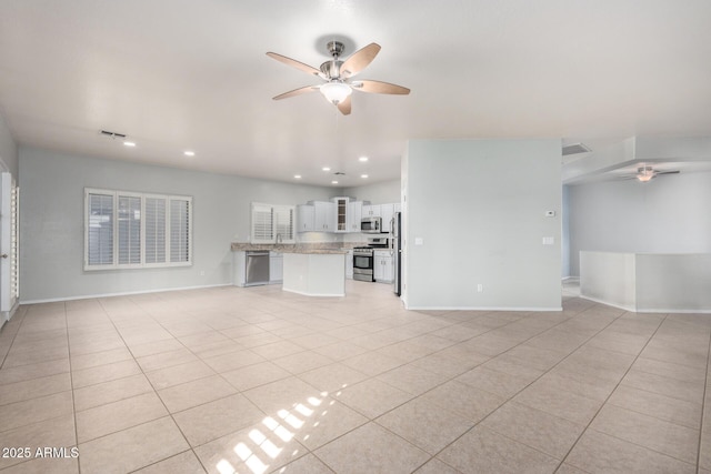 unfurnished living room featuring light tile patterned floors and ceiling fan