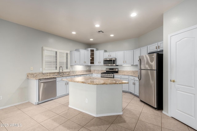 kitchen featuring stainless steel appliances, a center island, and white cabinets