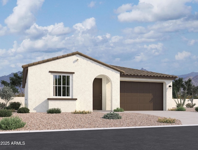 view of front of home featuring stucco siding, a mountain view, driveway, an attached garage, and a tiled roof