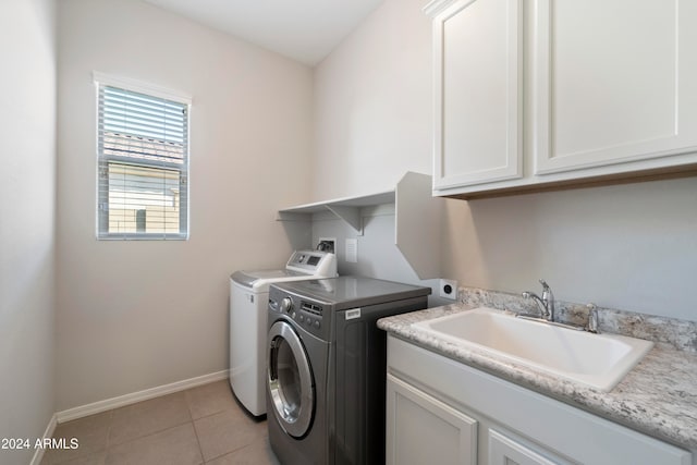 washroom featuring sink, cabinets, washing machine and clothes dryer, and light tile patterned floors