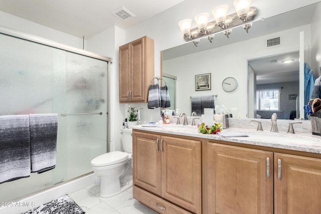 bathroom featuring a sink, marble finish floor, double vanity, and visible vents