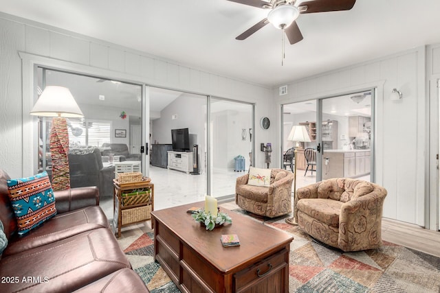 living area with a ceiling fan, light wood-style flooring, and visible vents