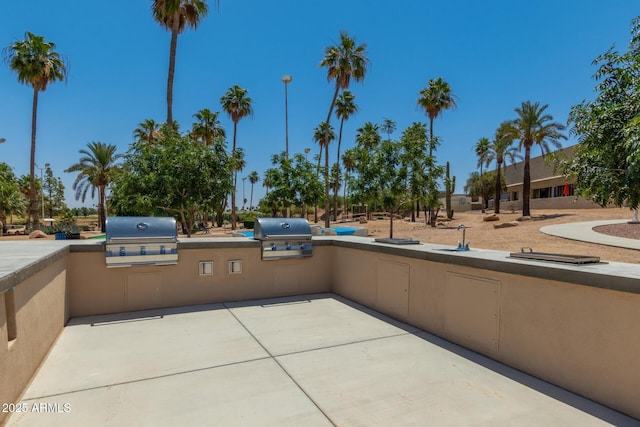 view of patio featuring a sink, area for grilling, and a grill