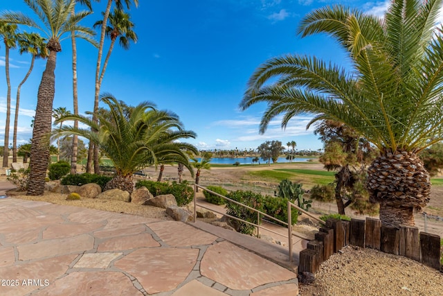 view of patio / terrace featuring fence and a water view