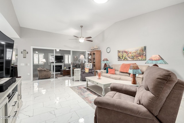 living area with a ceiling fan, vaulted ceiling, and marble finish floor