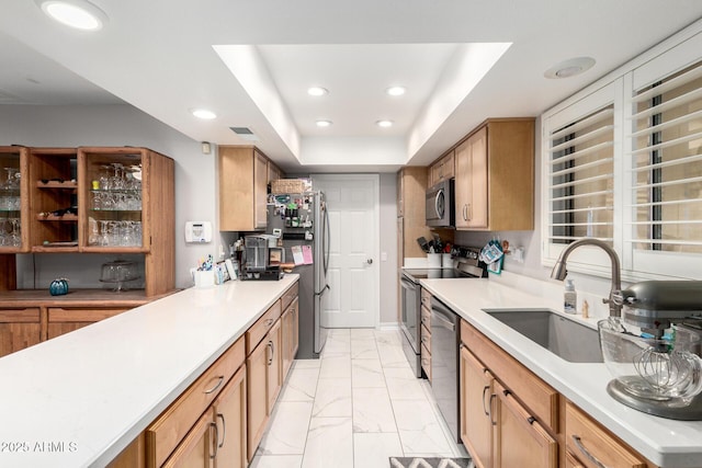 kitchen with marble finish floor, recessed lighting, light countertops, a sink, and appliances with stainless steel finishes