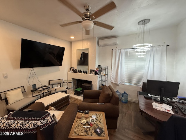 living room featuring hardwood / wood-style flooring, ceiling fan with notable chandelier, and an AC wall unit