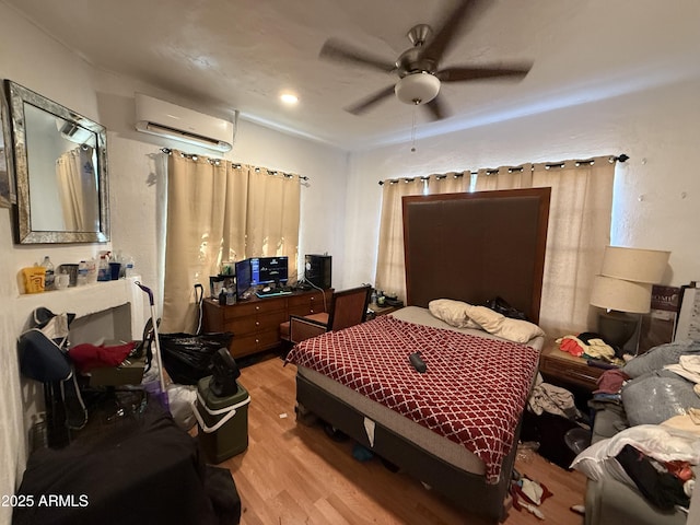 bedroom featuring an AC wall unit, ceiling fan, and light hardwood / wood-style flooring