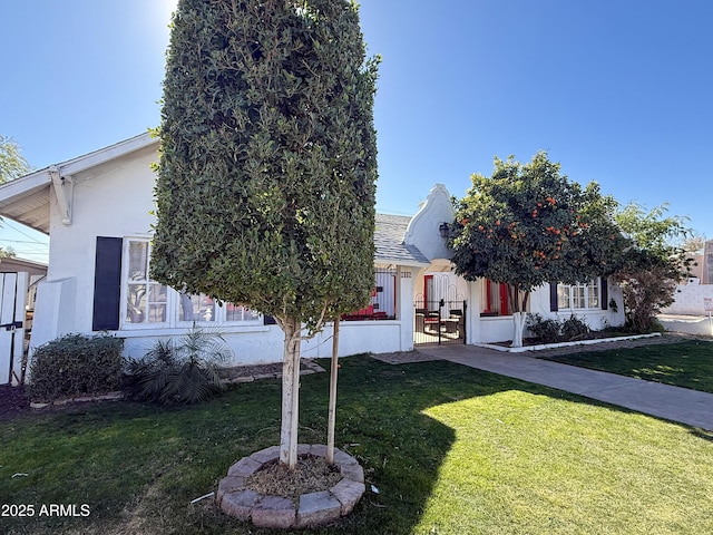 view of property hidden behind natural elements featuring a front lawn