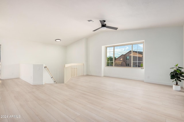 empty room with ceiling fan, lofted ceiling, and light wood-type flooring