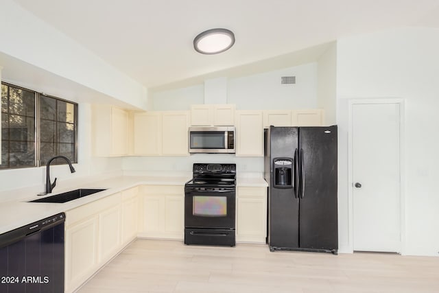 kitchen featuring light hardwood / wood-style floors, black appliances, sink, and vaulted ceiling