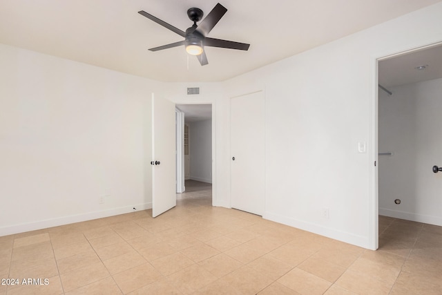 tiled spare room featuring ceiling fan