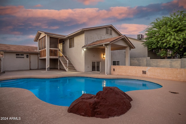 pool at dusk featuring a patio area