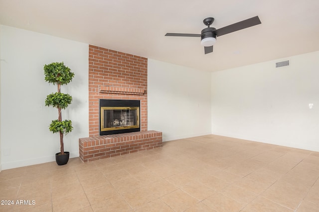 unfurnished living room with ceiling fan, light tile patterned flooring, and a fireplace