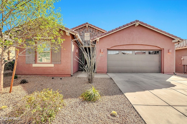 single story home with driveway, an attached garage, a tiled roof, and stucco siding