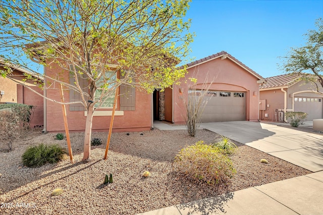 view of front of home with a garage, driveway, a tiled roof, and stucco siding