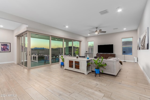 living room with light hardwood / wood-style floors and ceiling fan