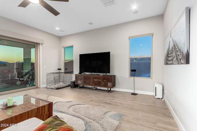 living room with ceiling fan and light hardwood / wood-style flooring