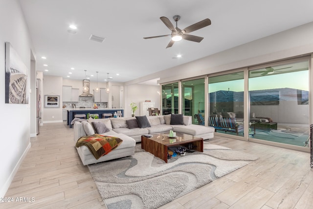 living room with light wood-type flooring and ceiling fan