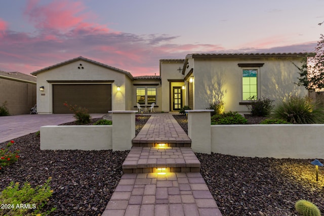 mediterranean / spanish house with a garage and covered porch