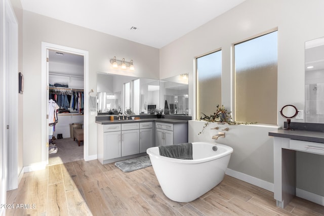 bathroom featuring a tub, wood-type flooring, and vanity