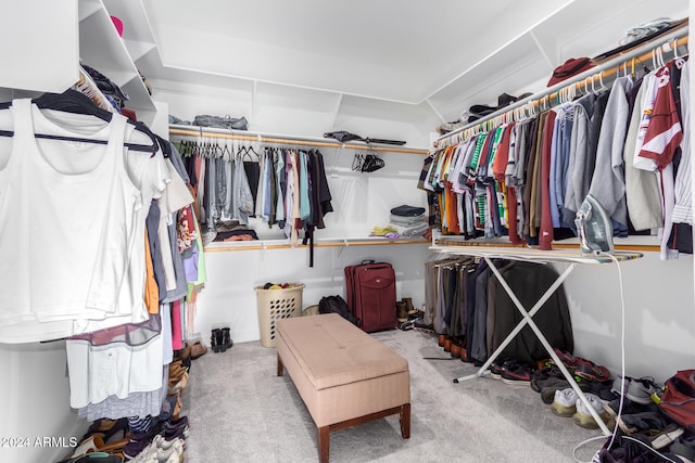 walk in closet featuring light carpet