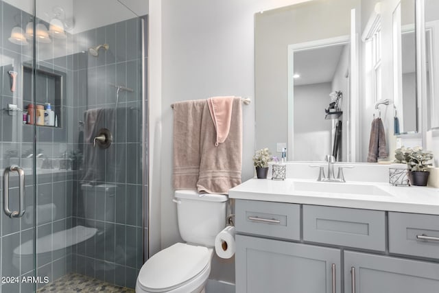 bathroom with walk in shower, vanity, and toilet