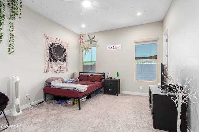 bedroom with multiple windows, light colored carpet, and ceiling fan