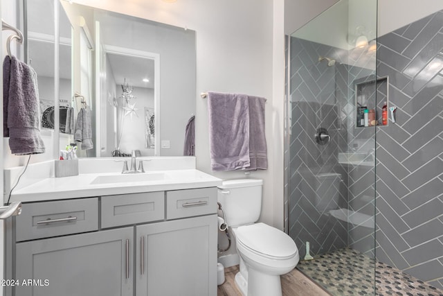 bathroom featuring walk in shower, hardwood / wood-style floors, vanity, and toilet